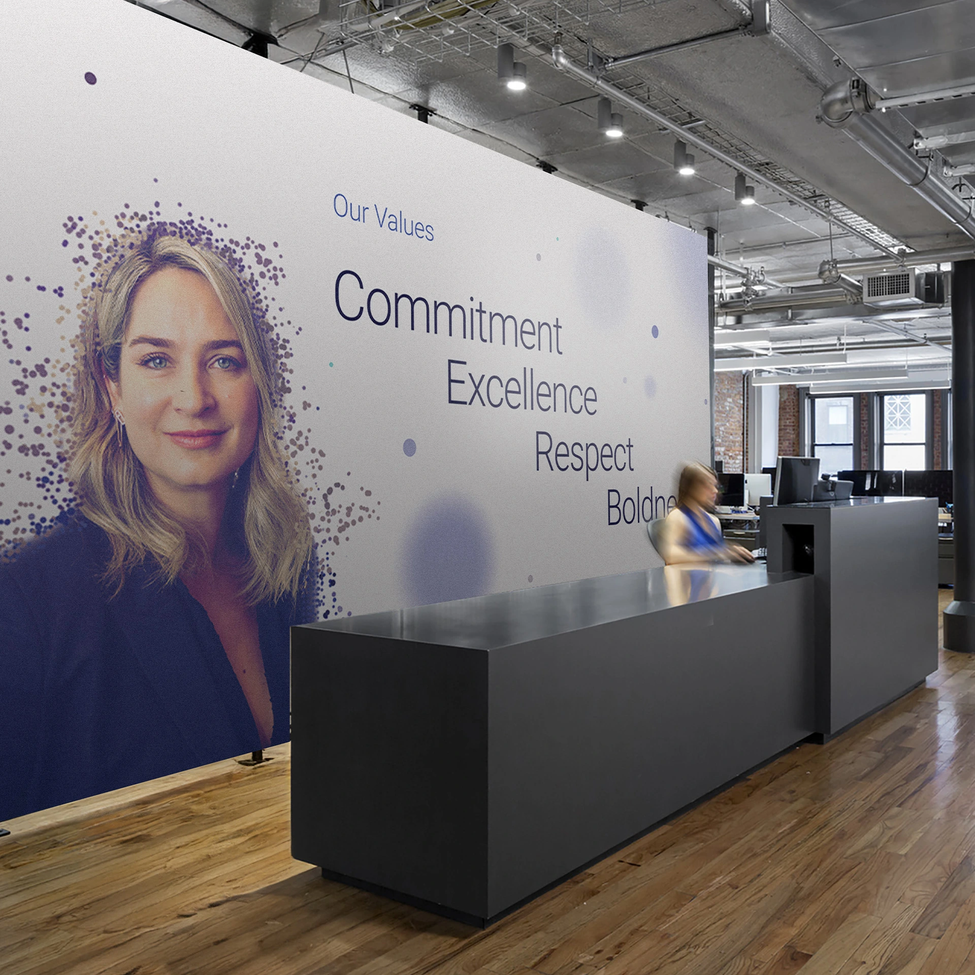 Office reception desk with a large branded company values wall graphic