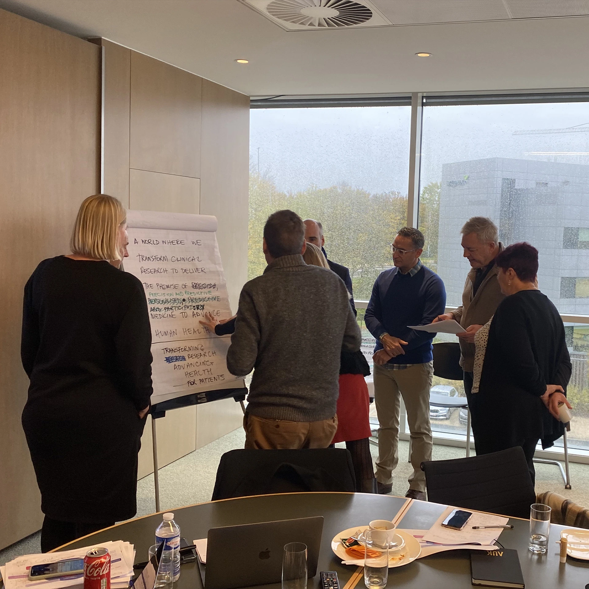 Workshop attendees discussing ideas around a flip chart