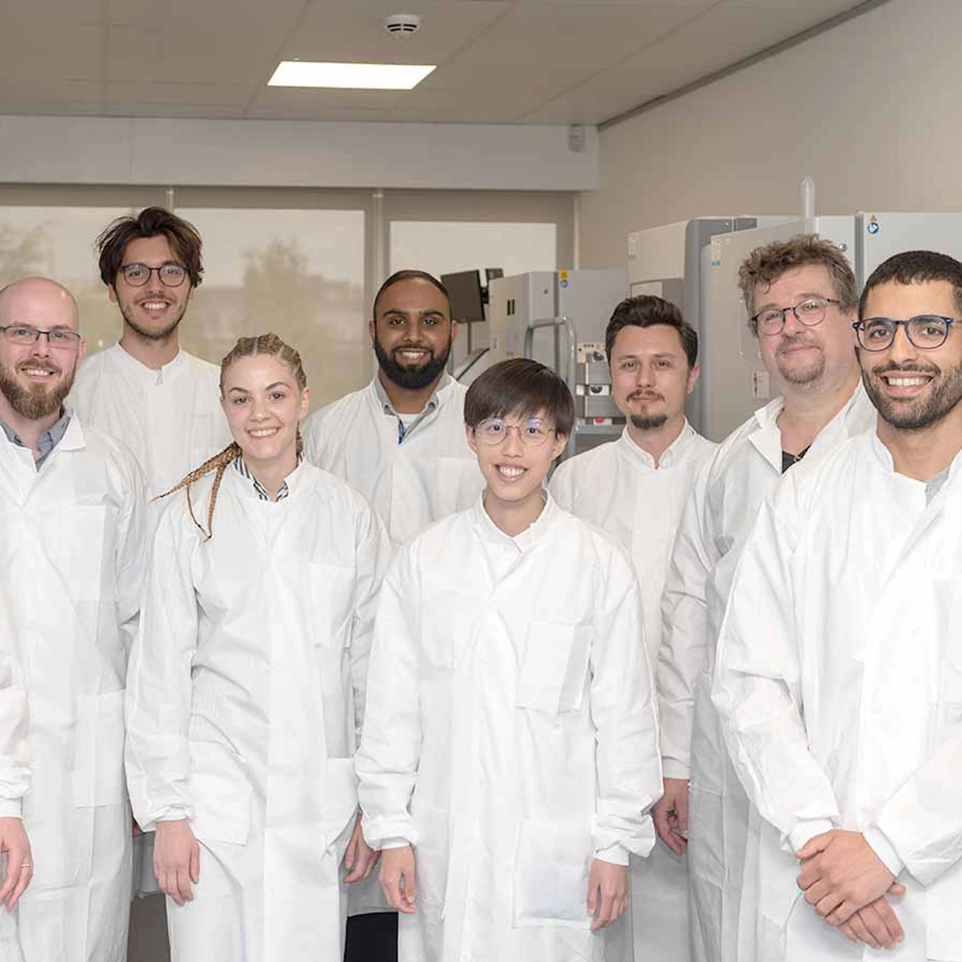 CN Bio scientists in lab coats posing together in a laboratory