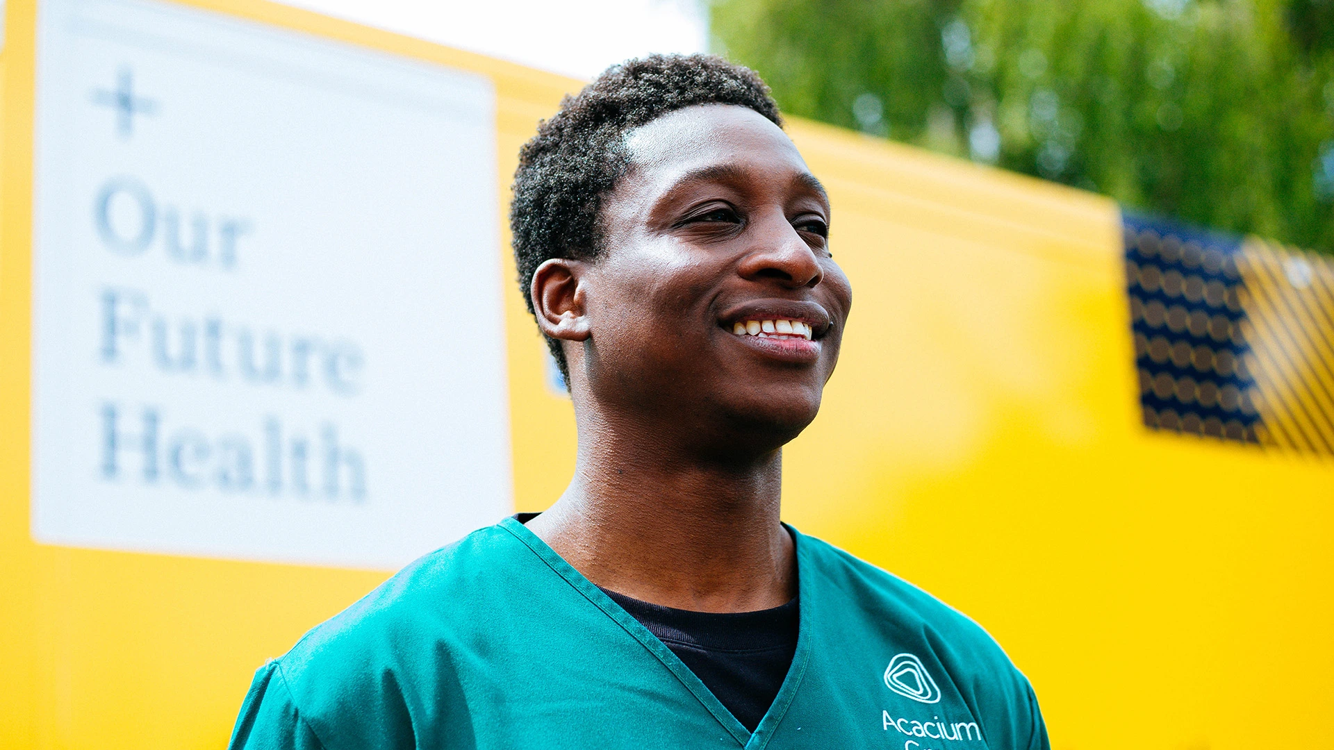 Smiling Our Future Health volunteer in front of a yellow campaign van