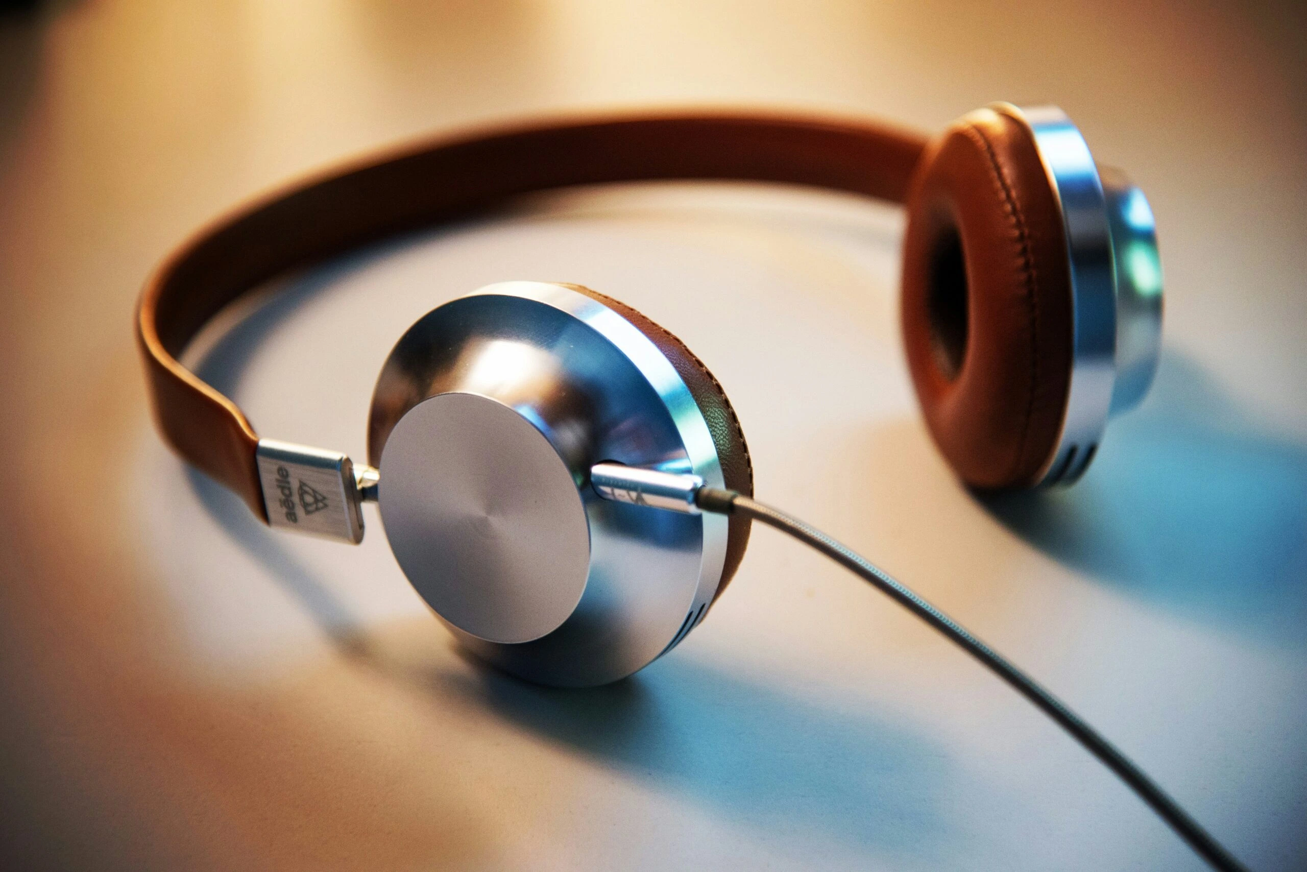 Silver and brown headphones resting on a table