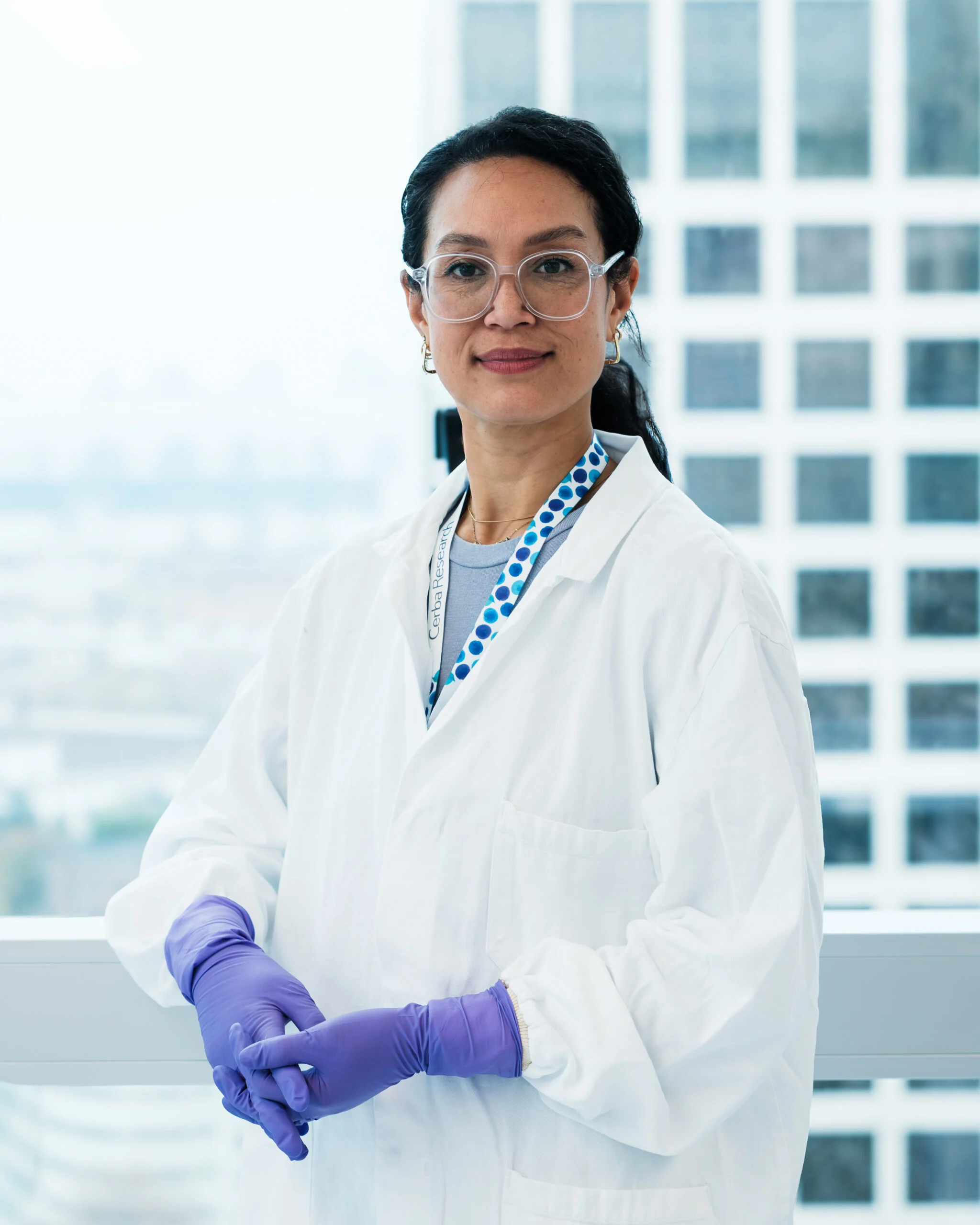 Cerba Research scientist in a lab coat and purple gloves