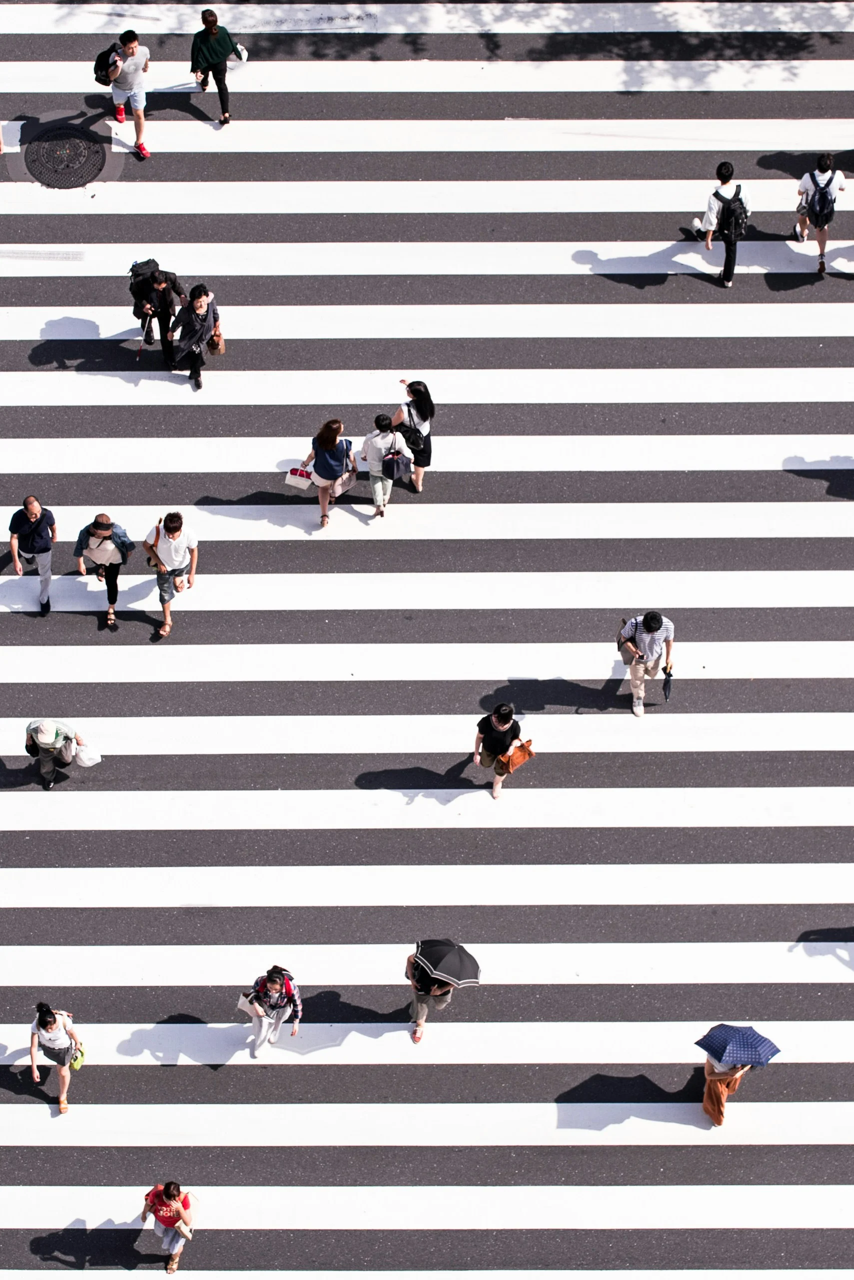 Aerial view of pedestrians walking across a zebra crossing