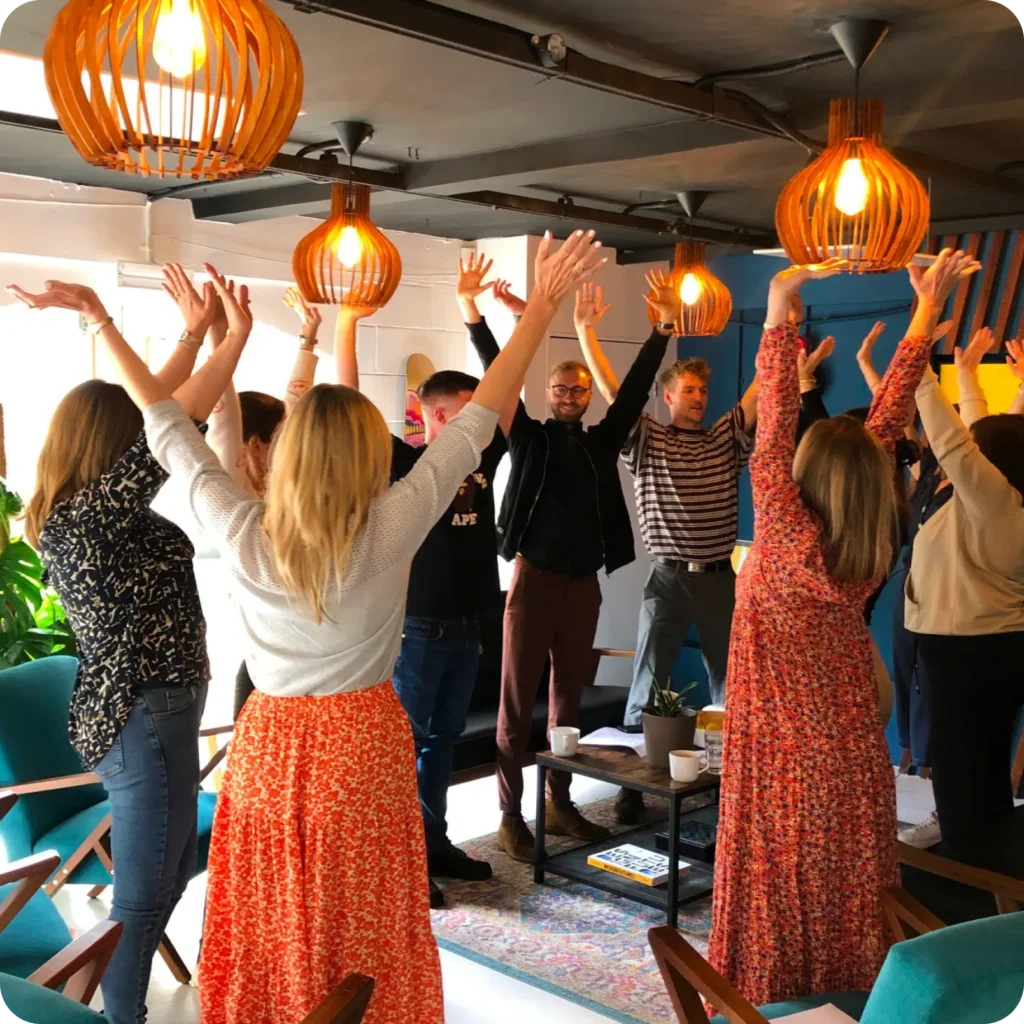 AgencyUK team dancing with arms raised in the office