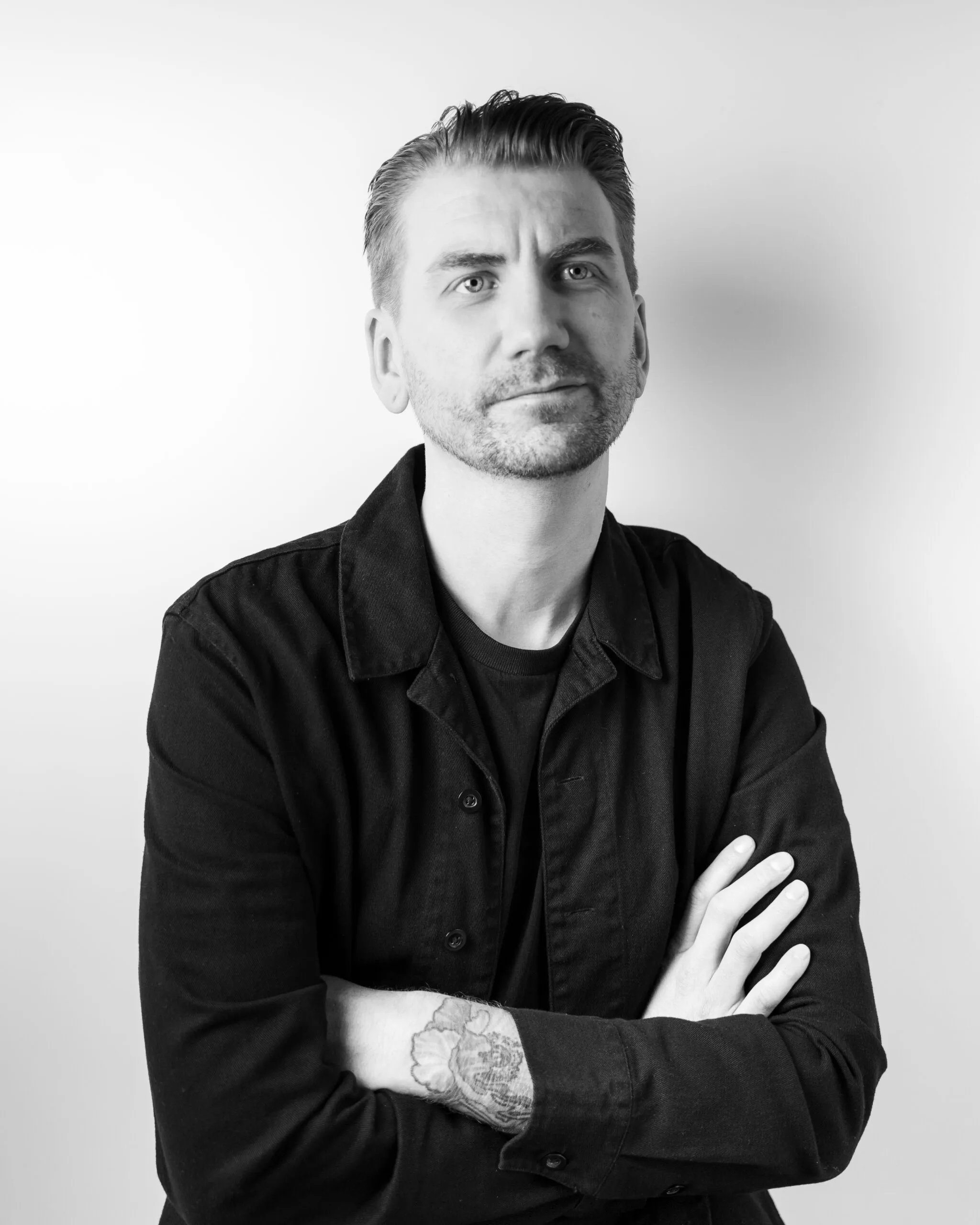 Black and white portrait of an AgencyUK team member, arms crossed