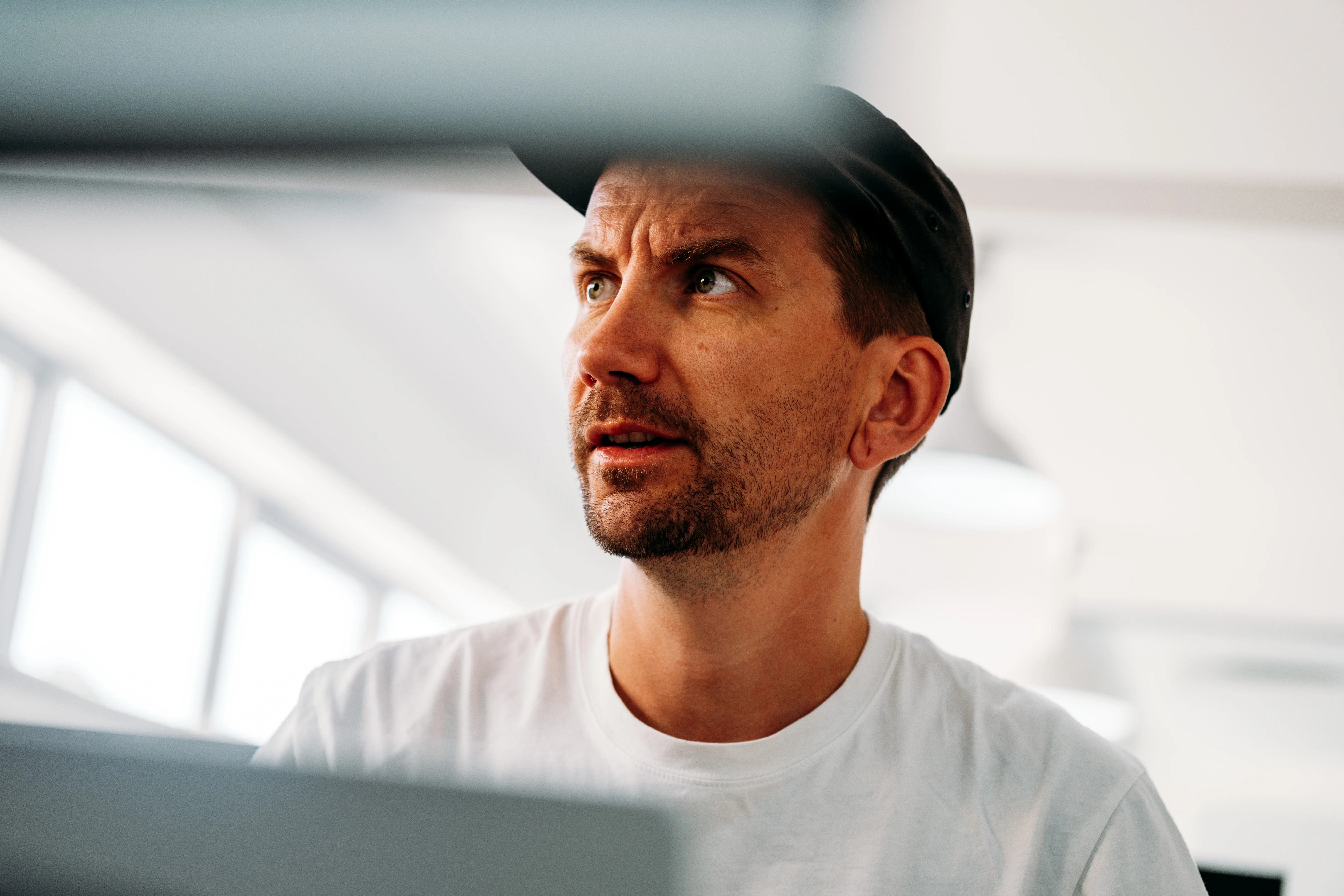AgencyUK team member in a cap looking up thoughtfully