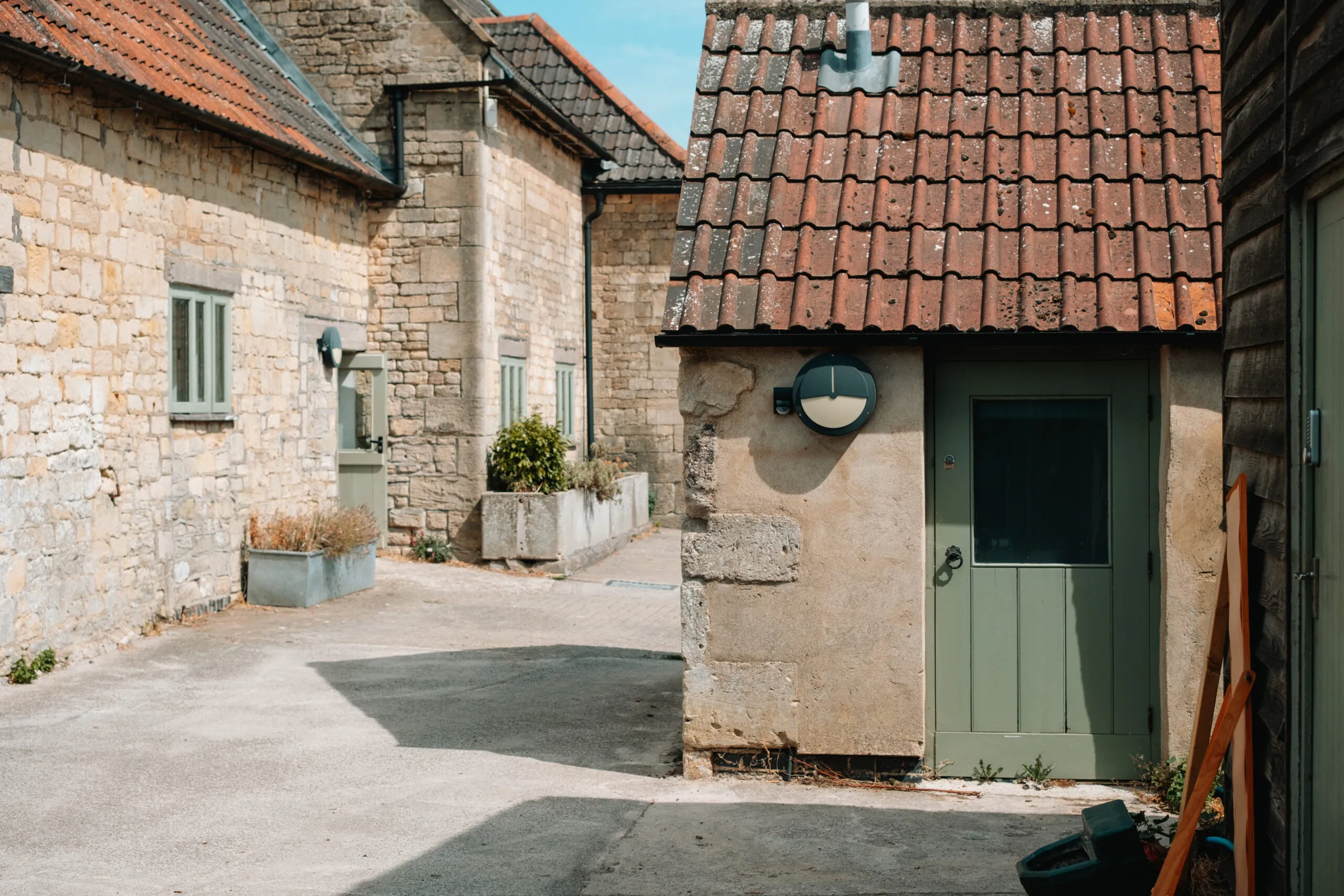 Cotswold stone buildings around a sunny courtyard
